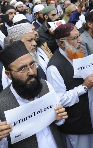 Members of the British Muslim Forum with religious leaders from Christian and Jewish faiths pay their respects to the victims of the Manchester Arena suicide bombing, at St Ann's square in Manchester, England Sunday May 28, 2017. (AP Photo/Rui Vieira)