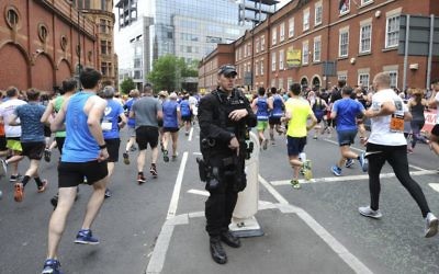 A week after a suicide bombing at an Ariana Grande concert in Manchester, northern England, armed response police stand at the ready at the start of the Great Manchester Run, Sunday May 28 2017. (AP Photo/Rui Vieira)
