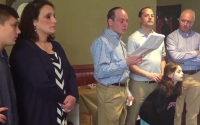 (From L-R) Ruth Schwartz looks on as her husband Ari reads a speech in memory of their son Ezra at a Rutgers University ceremony posthumously making inducting him as a member on April 30, 2017. Standing next to Ari are former AEPi presidents Seth Greenfield and Seth Jonas. (Screen capture/USA Today)
