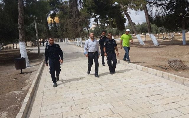 MK Masud Ghnaim of the Joint List is escorted off the Temple Mount by Israeli police on May 20, 2017 (Courtesy)