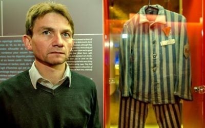 French historian Laurent Thiery poses near the camp clothes of a deportee forced to work at the underground weapon factory producing the Nazis' V2 rocket. (AFP/Philippe Huguen) 