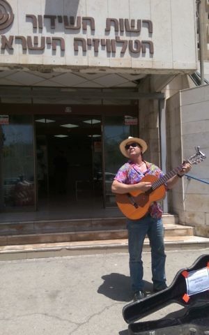 Arieh O'Sullivan, a former IBA English news anchor, strumming his guitar in farewell to the former Israel broadcasting authority (Courtesy Arieh O'Sullivan)