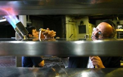 The rabbi in charge of keeping the Sheraton Crown Plaza kosher uses a gas torch to burn away any traces of leavening in the hotel's kitchen, prior to the Passover holiday,  Jerusalem,  April 2,  2006. ( The Sheraton was not featured in Channel 10‘s probe).  Olivier Fitoussi/Flash90