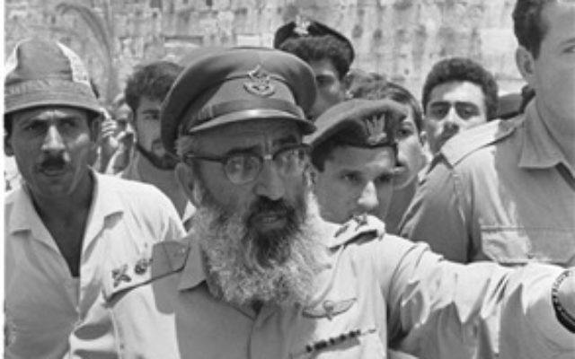Israel Defense Forces Chief Rabbi Shlomo Goren gestures against the backdrop of the Western Wall, June 22, 1967. (From the collection of Dan Hadani, National Library of Israel). Israel Defense Forces Chief Rabbi Shlomo Goren gestures against the backdrop of the Western Wall, June 22, 1967. (From the collection of Dan Hadani, National Library of Israel).