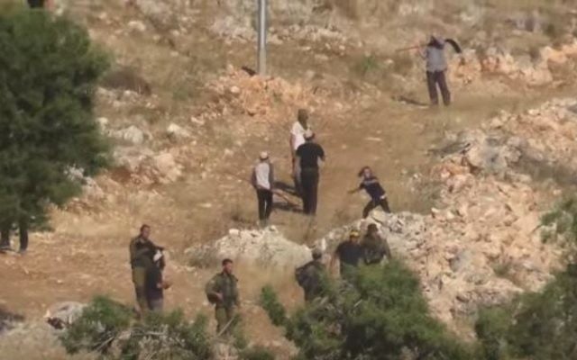 An image from a video showing Israeli settlers attacking Palestinians in the northern West Bank on April 12, 2017. (screen capture: YouTube/YeshDin) An image from a video showing Israeli settlers attacking Palestinians in the northern West Bank on April 12, 2017. (screen capture: YouTube/YeshDin)