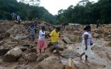 Sri Lankan villagers cross a landslide site as military rescue workers and villagers search for survivors in Athweltota village in Kalutara on May 28, 2017. (AFP PHOTO / LAKRUWAN WANNIARACHCHI)