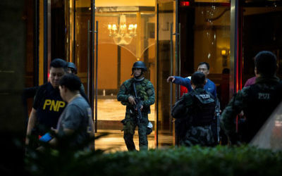 Philippines police officers come out from the Resorts World Hotel in Manila on June 2, 2017 following an assault. (Noel Celis/AFP)