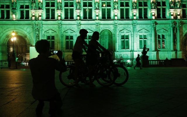 A picture taken on June 1, 2017, shows the City Hall of Paris illuminated in green following the announcement by US President Donald Trump that the United States will withdraw from the 2015 Paris accord and try to negotiate a new global deal on climate change. (AFP PHOTO / GEOFFROY VAN DER HASSELT)