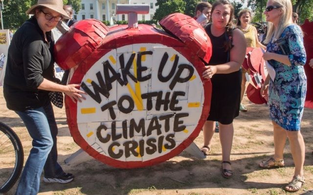 Protesters hold up signs during a demonstration in front of the White House in Washington, DC on June 1, 2017, objecting to US President Donald Trump's decision to withdraw from the Paris Climate accord.(AFP/Paul J. Richards) Protesters hold up signs during a demonstration in front of the White House in Washington, DC on June 1, 2017, objecting to US President Donald Trump's decision to withdraw from the Paris Climate accord.(AFP/Paul J. Richards)