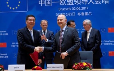 European Commissioner for Economic and Financial Affairs Pierre Moscovici (R) shakes hands with Yu Guangzhou, Minister of the General Administration of Customs of China during a EU China summit next to European Council President Donald Tusk (back-L) Chinese Premier Li Keqiang (back-C) and European Commission President Jean-Claude Juncker (back-R) on June 2, 2017 in Brussels. (Virginia Mayo / POOL / AFP)