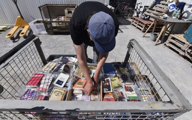 A volunteer sorts through books about to be fixed onto the 'Parthenon of Books' by Argentinian artist Marta Minujin, at the Documenta 14 art exhibition, in Kassel, Germany, June 2, 2017. (AFP/John MACDOUGALL)