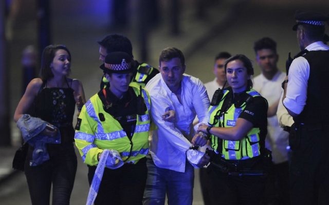 Police escort a member of public as they clear the scene of a terror attack on London Bridge in central London on June 3, 2017. (AFP PHOTO / DANIEL SORABJI) Police escort a member of public as they clear the scene of a terror attack on London Bridge in central London on June 3, 2017. (AFP PHOTO / DANIEL SORABJI)