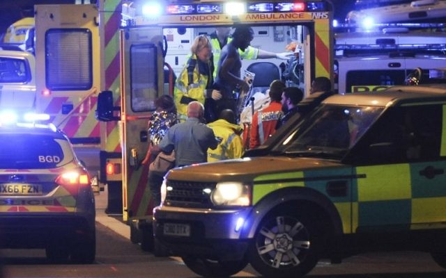 Police officers and members of the emergency services attend to a person injured in a terror attack on London Bridge in central London on June 3, 2017. (AFP PHOTO / DANIEL SORABJI)