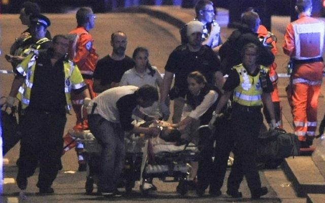 Police officers and members of the emergency services attend to a person injured in a terror attack on London Bridge in central London on June 3, 2017. (AFP PHOTO / DANIEL SORABJI) Police officers and members of the emergency services attend to a person injured in a terror attack on London Bridge in central London on June 3, 2017. (AFP PHOTO / DANIEL SORABJI)