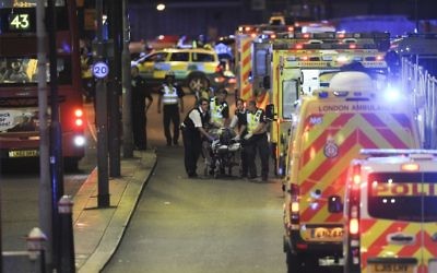 Police officers and members of the emergency services attend to a person injured in a terror attack on London Bridge in central London, June 3, 2017. (AFP/Daniel Sorabji)