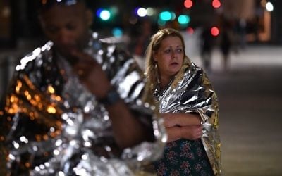 Members of the public, wrapped in emergency blankets leave the scene of a terror attack on London Bridge in central London on June 3, 2017. (AFP PHOTO / Chris J Ratcliffe)