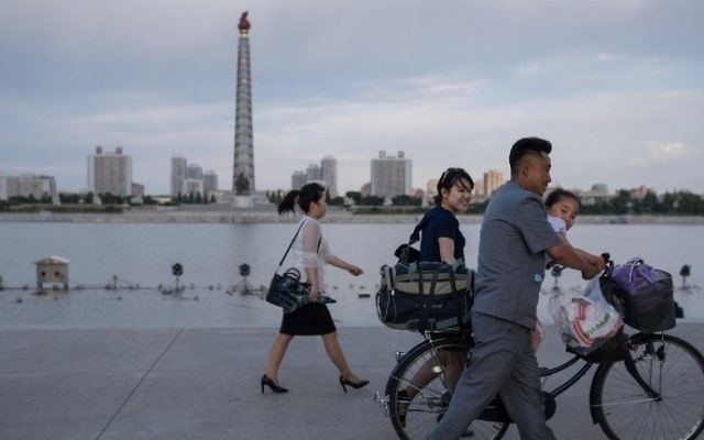 In a photo taken on June 4, 2017 a man pushes a child on a bicycle past the Juche tower and Taedong river in Pyongyang, North Korea (AFP Photo/Ed Jones) In a photo taken on June 4, 2017 a man pushes a child on a bicycle past the Juche tower and Taedong river in Pyongyang, North Korea (AFP Photo/Ed Jones)