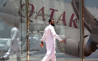 A man walking past the Qatar Airways branch in the Saudi capital Riyadh, after it had suspended all flights to Saudi Arabia following a severing of relations between major gulf states and gas-rich Qatar, June 5, 2017. (AFP/FAYEZ NURELDINE)