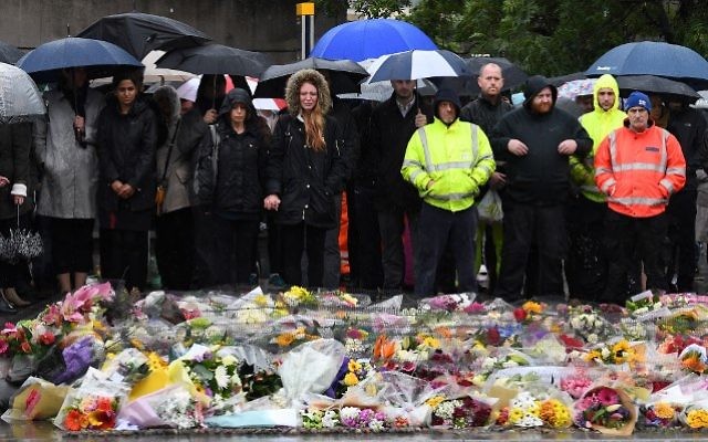 People observe a minutes' silence at south-side of London Bridge in London on June 6, 2017, in memory of the victims of the June 3 terror attacks. (AFP PHOTO / Justin TALLIS)