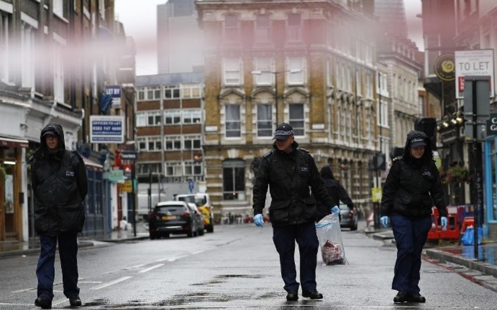 A Police officer carries an evidence bag as he works with colleagues on Borough High Street, close to Borough Market, in London on June 6, 2017, as the police investigations continue following the June 3 terror attack. (AFP PHOTO / Odd ANDERSEN)