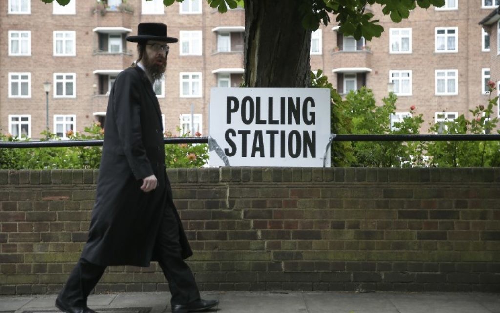 Illustrative: An ultra-Orthodox Jewish man walks past a polling station sign in northeast London, June 8, 2017. (AFP/Daniel Leal-Olivas) Illustrative: An ultra-Orthodox Jewish man walks past a polling station sign in northeast London, June 8, 2017. (AFP/Daniel Leal-Olivas)