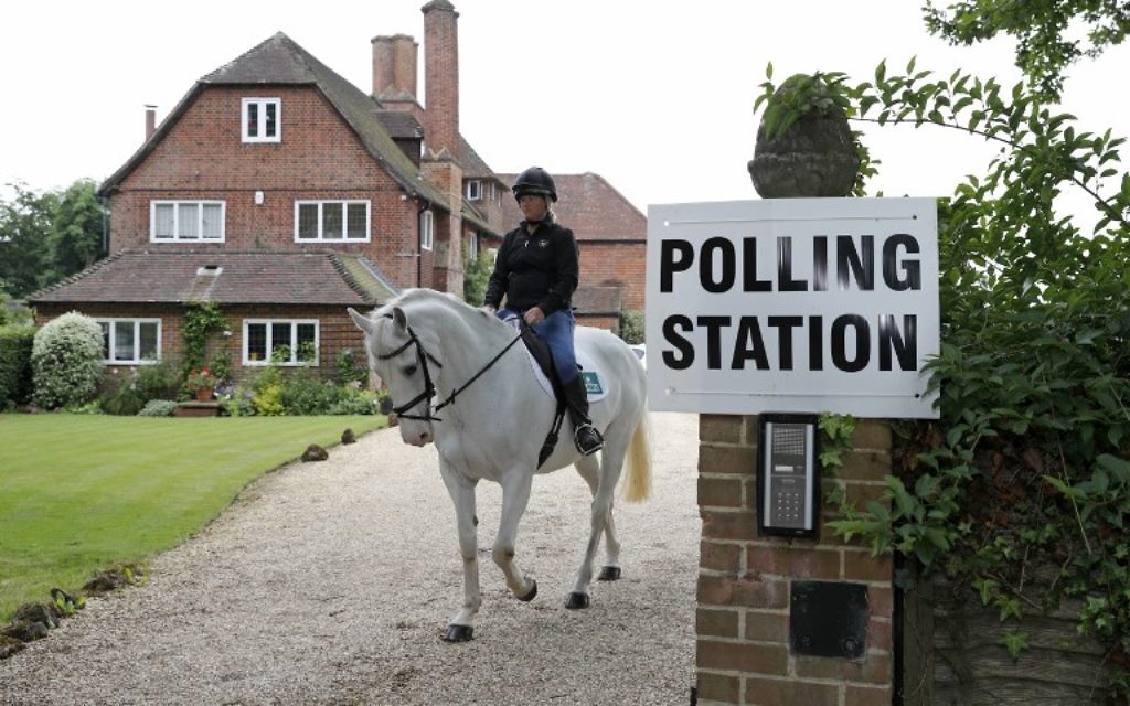 Sophie Allison, riding her horse Splash, rides out of the driveway of a private residence, set up as a Polling Station, near Reading, west of London, on June 8, 2017. (AFP/Adrian DENNIS)