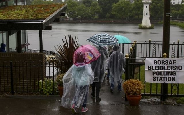 People are pictured outside a polling station at Roath Park Lake in Cardiff, Wales, June 8, 2017. (AFP/Geoff CADDICK)