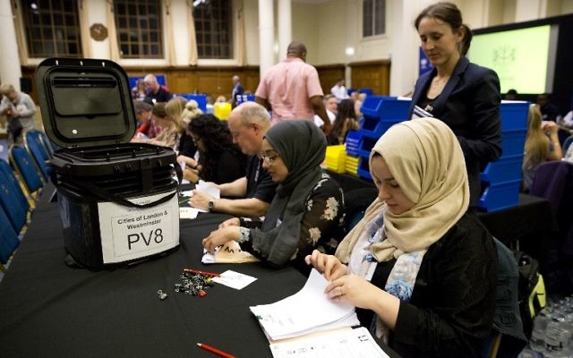 Counting staff count ballots at a counting centre in Methodist Central Hall, Westminster, London, on June 8, 2017, after the polls closed in Britain's general election. (AFP PHOTO / Isabel INFANTES)