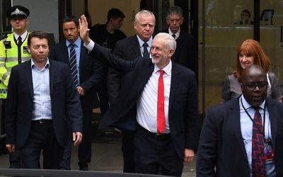 Britain's opposition Labour leader Jeremy Corbyn waves as he leaves the Labour Party headquarters in central London on June 9, 2017 after results in a snap general election show a hung parliament with Labour gains and the Conservative Party losing its majority. (AFP/Paul Ellis)