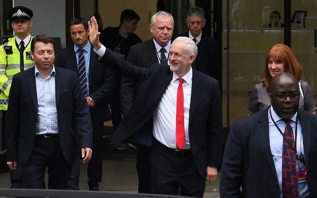 Britain's opposition Labour leader Jeremy Corbyn waves as he leaves the Labour Party headquarters in central London on June 9, 2017 after results in a snap general election show a hung parliament with Labour gains and the Conservative Party losing its majority. (AFP/Paul Ellis)