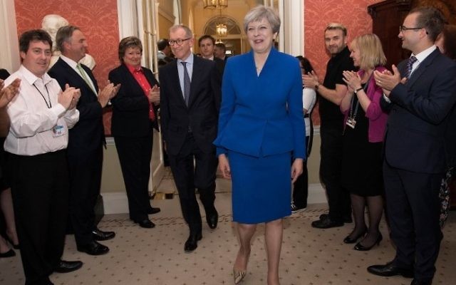 Britain's Prime Minister Theresa May and her husband Philip are clapped into 10 Downing Street by the staff after her visit with Britain's Queen Elizabeth II at Buckingham Palace where, despite her Conservative Party losing its overall majority, she was requested to form a new government, in central London on June 9, 2017 (AFP PHOTO / POOL / Stefan Rousseau)