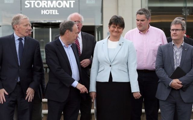 Flanked by her members of Parliament, Democratic Unionist Party (DUP) leader, and former Northern Ireland First Minister, Arlene Foster (C), poses for a photograph outside the Stormont Hotel in Belfast, Northern Ireland, on June 9, 2017, following the result of the general election. (AFP PHOTO / Paul FAITH)