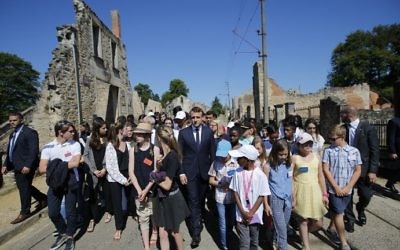 French President Emmanuel Macron (C) walks with children during a ceremony to commemorate the 73rd anniversary of the Oradour-sur-Glane massacre in the village of Oradour-sur-Glane on June 10, 2017. (AFP/Pool/Stephane Mahe)