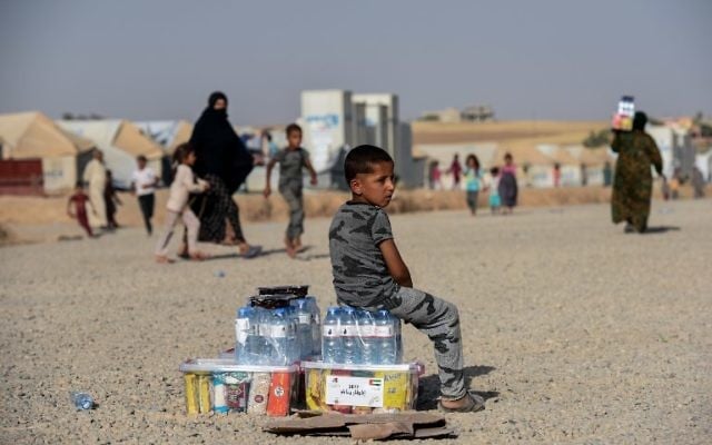 A displaced Iraqi child sits at the Hasan Sham camp for internally displaced people in Iraq, June 10, 2017. (AFP/MOHAMED EL-SHAHED)