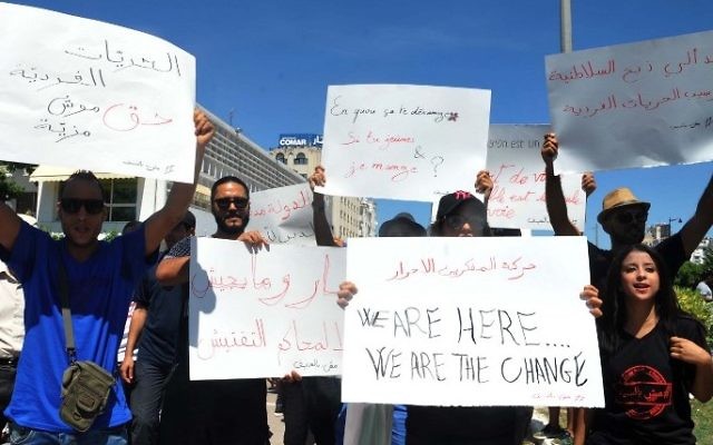 Tunisian protesters hold placards during a demonstration for the right to eat and smoke in public during the Muslim dawn-to-dusk fasting month of Ramadan, on June 11, 2017, in Tunis. (AFP/ Sofienne HAMDAOUI)