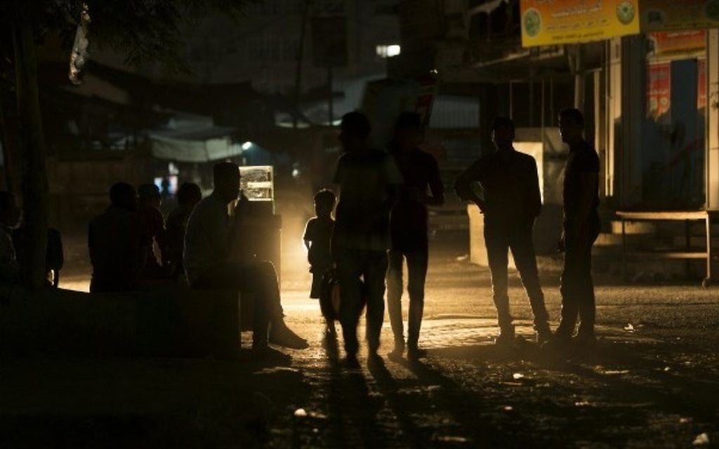 Palestinians walk on a street at the Al-Shati refugee camp in Gaza City during a power outage on June 11, 2017. (AFP Photo/Mahmud Hams)