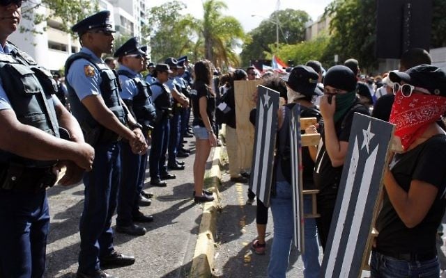 Protesters line up in front of Puerto Rico Police officers during a protest against the referendum for Puerto Rico political status in San Juan, on June 11, 2017. (AFP PHOTO / Ricardo ARDUENGO)