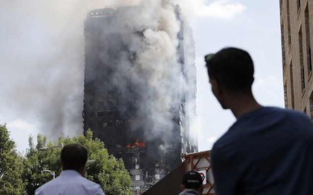 Pedestrians look up towards Grenfell Tower, a residential block of flats in west London on June 14, 2017, as firefighters continue to control a fire that engulfed the building in the early hours of the morning. (AFP PHOTO / Adrian DENNIS) Pedestrians look up towards Grenfell Tower, a residential block of flats in west London on June 14, 2017, as firefighters continue to control a fire that engulfed the building in the early hours of the morning. (AFP PHOTO / Adrian DENNIS)