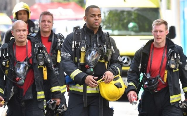 Firefighters work at the scene where a fire ripped through Grenfell Tower, a residential block in west London on June 14, 2017. (AFP PHOTO / Ben STANSALL