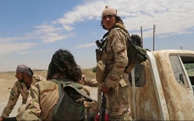 Opposition members of Ahmad Jarba's Syrian Elite Forces, fighting alongside the Syrian Democratic Forces (SDF), ride a truck in a neighborhood on the eastern front of the Islamic State (IS) group's Syrian bastion of Raqa during an offensive to retake the city from the jihadists on June 14, 2017. 
(Delil Souleiman/AFP)