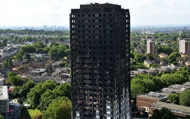 The remains of Grenfell Tower, a residential tower block in west London which was gutted by fire, are pictured against the London skyline on June 16, 2017. AFP / CHRIS J RATCLIFFE)