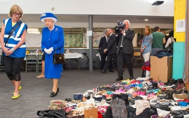 Britain's Queen Elizabeth II is shown donations of aid, made by members of the local community, by Executive Director of Kensington and Chelsea Council, Sue Harris during a visit to the Westway Sports Center which is providing temporary shelter for those who have been made homeless in the Grenfell Tower disaster, in west London on June 16, 2017. AFP / POOL / Dominic Lipinski)