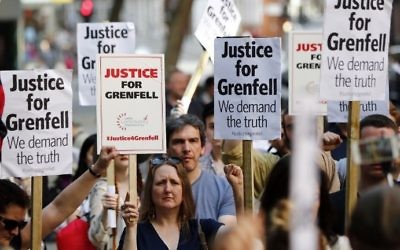 Demonstrators gather with placards outside the Department for Communities and Local Government in central London on June 16, 2017 to demand justice for those affected by the Grenfell Tower fire. (AFP/Tolga Akmen)