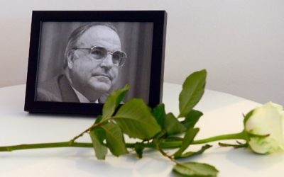 A photograph of former German Chancellor Helmut Kohl and a white rose are seen next to a book of condolences for Kohl at the conservative Christian Democratic Union's regional party congress in Berlin on June 17, 2017. (Maurizio Gambarini/DPA/AFP)
