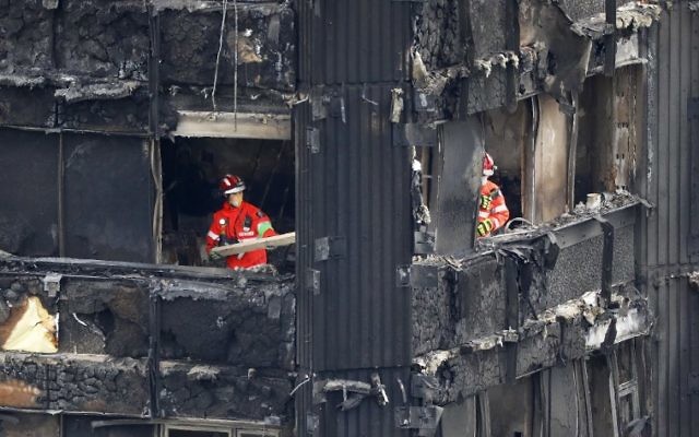 Members of the emergency services work on the middle floors of the charred remnains of the Grenfell Tower block in Kensington, west London, on June 17, 2017, follwing the June 14 fire at the residential building. ( AFP PHOTO / Tolga AKMEN)