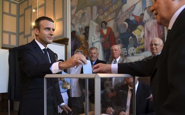 French President Emmanuel Macron casts his ballot as he votes at a polling station in Le Touquet, northern France, during the second round of the French parliamentary elections on June 18, 2017. (AFP PHOTO / POOL / CHRISTOPHE ARCHAMBAULT