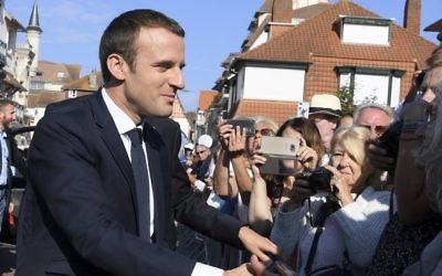 French President Emmanuel Macron shakes hands with people as he arrives to vote in Le Touquet, northern France, during the second round of the French parliamentary elections on June 18, 2017 (AFP PHOTO / POOL / CHRISTOPHE ARCHAMBAULT)