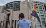 A person waves a rainbow flag in front of Istanbul courthouse on June 19, 2017 in support to eleven LBTG activists who went on trial for having marched during last year's Gay Pride, which was banned.  (AFP PHOTO / OZAN KOSE)