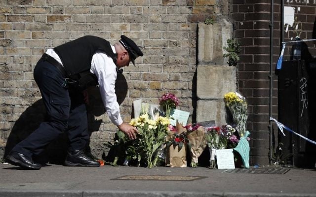 A police officer lays flowers inside a police cordon near the scene in Finsbury Park area of north London after a vehicle was driven into pedestrians, on June 19, 2017. (AFP PHOTO/Tolga AKMEN) A police officer lays flowers inside a police cordon near the scene in Finsbury Park area of north London after a vehicle was driven into pedestrians, on June 19, 2017. (AFP PHOTO/Tolga AKMEN)