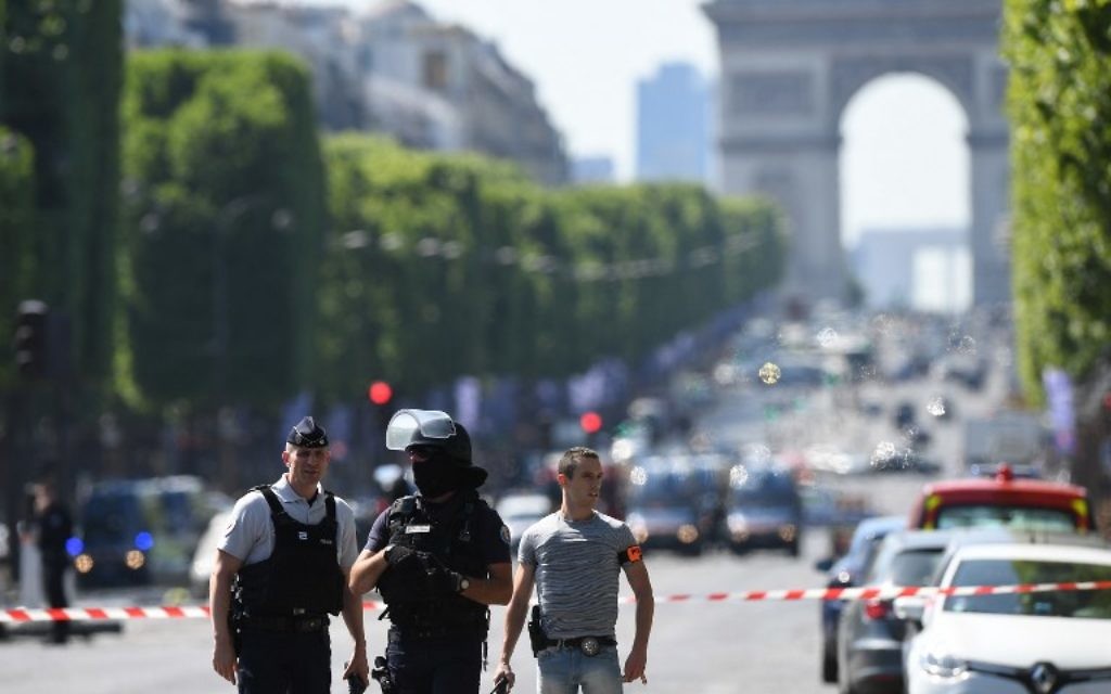 Policemen stand guard on the Champs-Elysees avenue in Paris, after a car crashed into a police van before bursting into flames, June 19, 2017. (AFP/ALAIN JOCARD)
